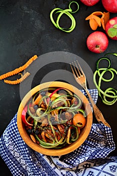 Colorful spiralized salad with carrots, cucumber, apples, nuts, and seeds