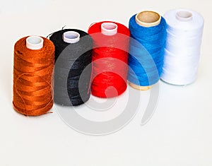 Colorful spools of sewing thread isolated on white background