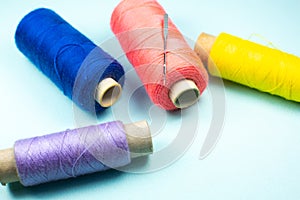 Colorful spools of thread with a needle, close up