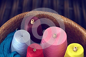 Colorful spools of thread in a wicker basket.