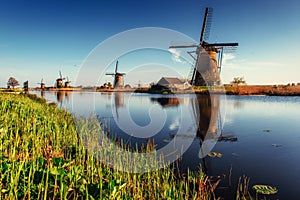 Colorful spring day with traditional Dutch windmills canal in Ro