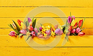 Colorful springtime flowers on yellow background photo