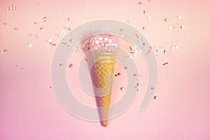 Colorful sprinkles on a pink background, top view with copy space