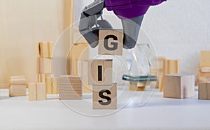 Colorful square papers with wooden white letters for the acronym word GIS means Geographic Information System