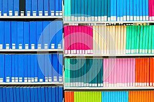 Colorful stack of research books in a university library, with blank book spines. Useful as a background