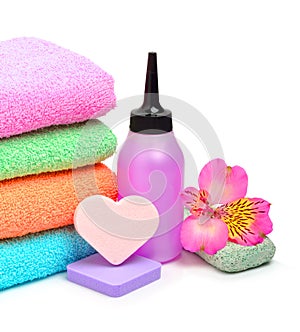 Colorful stacked spa towels, sponges and shampoo bottle