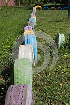 Colorful stacks of old used tyres wall.