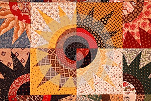 A colorful star burst quilt pattern made of triangles, squares and circles.