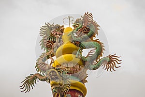 Colorful statue of Chinese dragon wrapped around the pillar. Beautiful statue of dragon carved around temple pole in Chinese