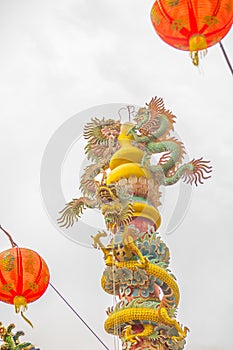 Colorful statue of Chinese dragon wrapped around the pillar. Beautiful statue of dragon carved around temple pole in Chinese