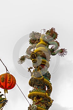 Colorful statue of Chinese dragon wrapped around the pillar. Beautiful statue of dragon carved around temple pole in Chinese