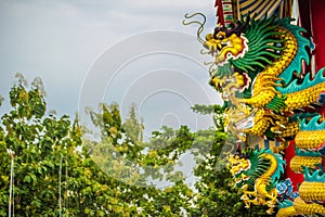 Colorful statue of Chinese dragon wrapped around the pillar. Beautiful statue of dragon carved around temple pole in Chinese