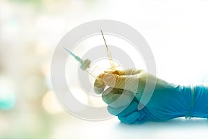 Colorful sterile syringe and glove doctor getting ready to inject patient on soft background, vibrant concept photo