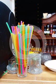 Colorful straws in a glass cup in pub.