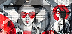 Colorful street art graffiti mural showing two beautiful japanese geishas