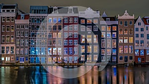 colorful street with house at the Damrak in Amsterdam, the call it the dancing house