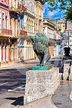 Colorful street in Old Havana with the bronze lion at El Prado