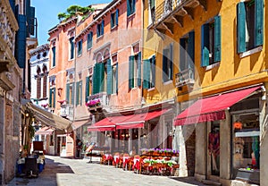 Colorful street with tables of cafe at a sunny morning, Venice, Italy photo