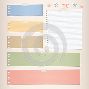 Colorful striped note, notebook paper for message or text stuck with sticky tape on brown background.