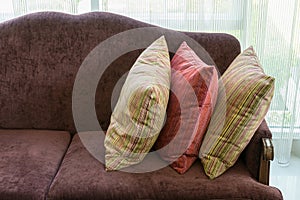 Colorful striped pillows on red sofa in luxury living room