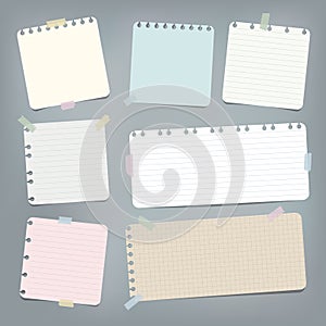 Colorful striped, ruled note, copybook, notebook paper stuck with sticky tape on grey background.