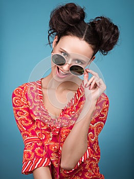 Colorful Studio portrait of cheerful young woman in sunglasses. Bright red blouse