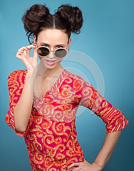 Colorful Studio portrait of young woman in sunglasses. Bright red blouse