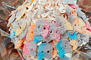 colorful sugar marmalade in the form of a skull and crossbones in the window of a candy store