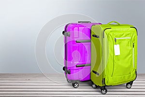 Two Colorful suitcases on wooden background