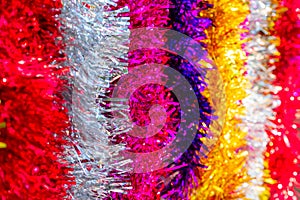 Colorful Sukkot or Sukkos or Christmas tinsel. New year`s fluffy gold, purple, silver, yellow, pink tinsel.