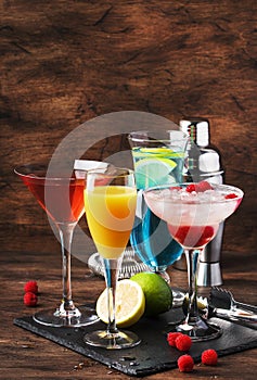 Colorful summer cocktails. Cold alcoholic beverages and drinks: mimosa, cosmopolitan, raspberry margarita and blue hawaii on