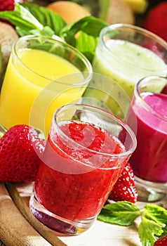 Colorful summer fruit and berry juices and smoothies in glasses: