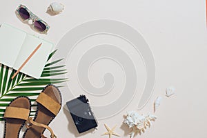 Colorful summer holidays fashion flat lay - straw hat, camera, sunglasses, sea shells on ligh background