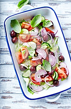 Colorful summer salad with kalamata olives in a ceramic dish