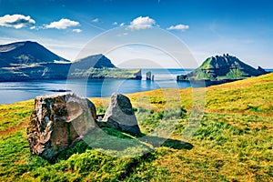 Colorful summer scene of Faroe Islands with Tindholmur cliffs on background, Vagar island, Denmark, Europe. Sunny morning seascape photo