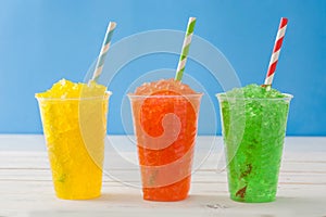 Colorful summer slushies on blue wood