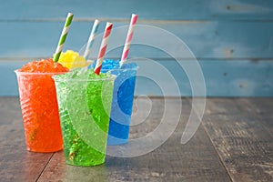 Colorful summer slushies on blue wood