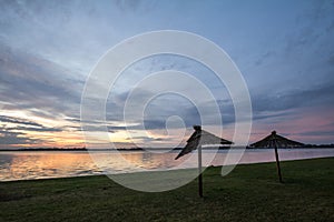 Colorful summer sunset on the Palic Lake, in Subotica, Serbia, while sun umbrella parasols are visible.