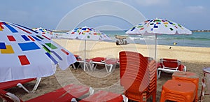 Colorful sun shadow umbrellas and orange chairs