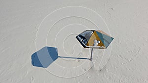 Colorful sun umbrella on a white snowy background.