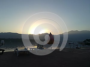 Colorful sunrise on the beach against the background of the sea and the mountains. Rest on the sea.