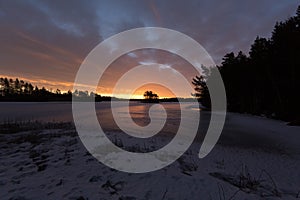 Colorful sunrise with clouds in the sky and frozen lake