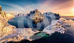 Colorful sunrise over Lofoten Islands and traditional norwegian fishing village in winter at Norway