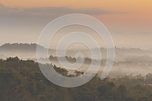 Colorful sunrise over Merapi volcano and Borobudur temple in misty jungle forest, Indoneisa