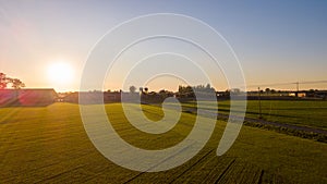 Colorful sunrise or sunset sky over a farmfield shot from high up