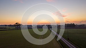 Colorful sunrise or sunset sky over a farmfield shot from high up