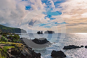 Colorful sunset on cliff with rocks in the ocean with islets of Mosteiros on the horizon, SÃ£o Miguel - Azores PORTUGAL