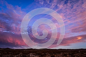 Colorful sunset clouds in sky above high desert landscape