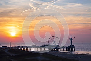 Colorful sunset on coastline, beach, pier and ferris wheel, Scheveningen, the Hague