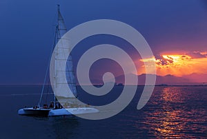 Colorful sunset. Dramatic and Atmospheric landscape. Costa Brava, Spain. Seacoast. Seascape with sailboat. Tourist catamaran.